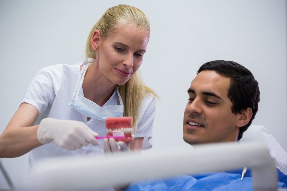 prothetist explaining how to use full denture while eating
